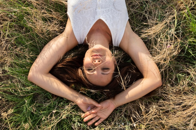 Kostenloses Foto draufsicht der frau, die in der natur auf gras entspannt