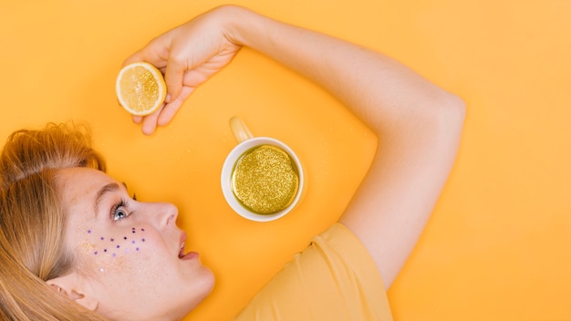 Kostenloses Foto draufsicht der frau mit cup und limonade in der gelben szene