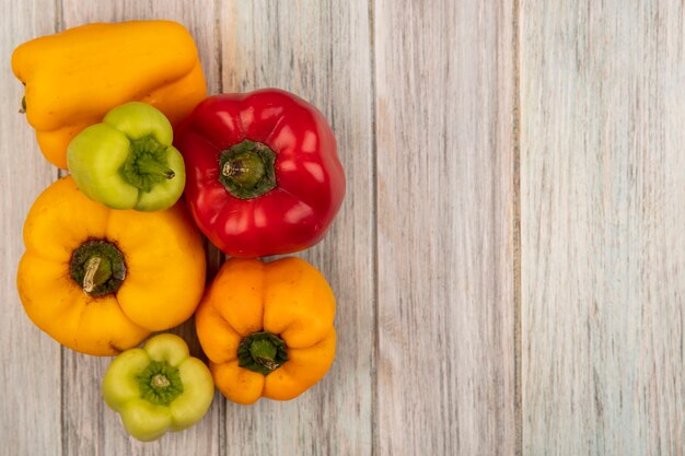 Draufsicht der frischen bunten Paprika lokalisiert auf einer grauen Holzoberfläche mit Kopienraum