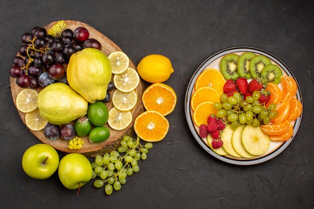 Draufsicht der frischen Fruchtzusammensetzung in Scheiben geschnitten und reif auf dunkler Oberfläche Fruchtreife frische, ausgereifte Gesundheit