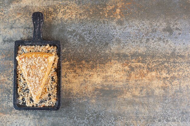 Draufsicht der frischen Kuchenscheibe auf Holzbrett über rustikal