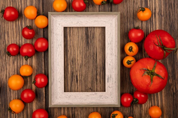 Draufsicht der frischen roten und orange Kirschtomaten lokalisiert auf einer Holzwand mit Kopienraum