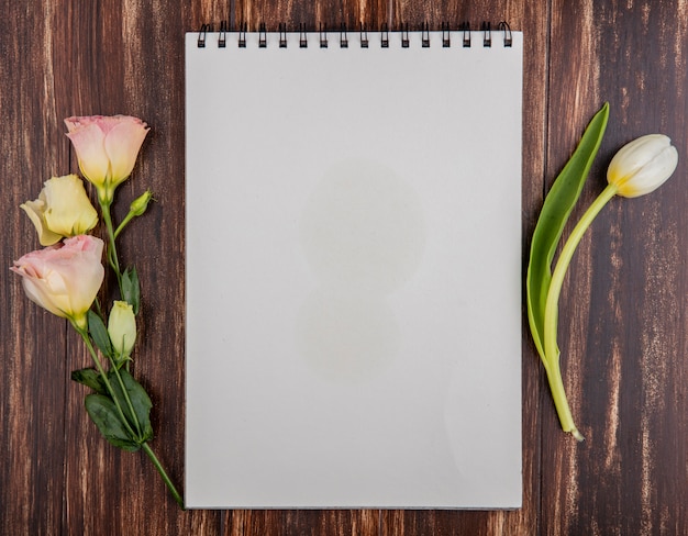 Draufsicht der frischen weißen Tulpe mit Rosen auf einem hölzernen Hintergrund mit Kopienraum
