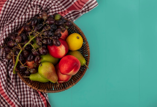 Draufsicht der Früchte als Korb der Birnenpfirsich-Zitronen-Traube auf blauem Hintergrund mit Kopienraum