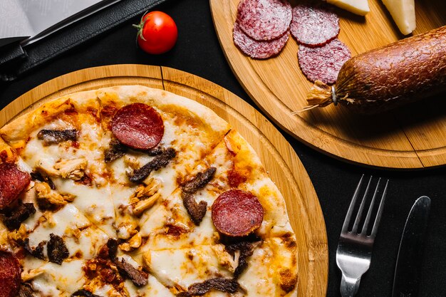 Draufsicht der gemischten Fleischpizza mit Peperoni, Huhn und Rindfleisch
