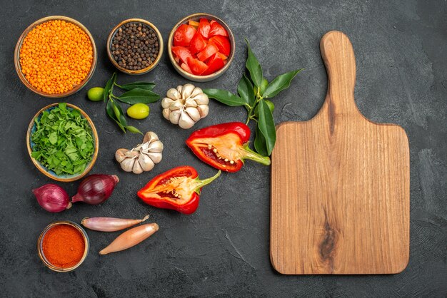 Draufsicht der Gemüseschüssel der Linsenkräutergewürze Tomaten Paprika das Schneidebrett