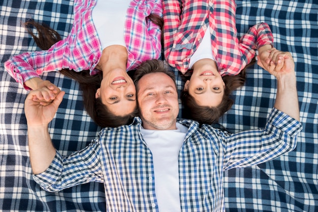 Draufsicht der glücklichen familie liegend auf blauer decke