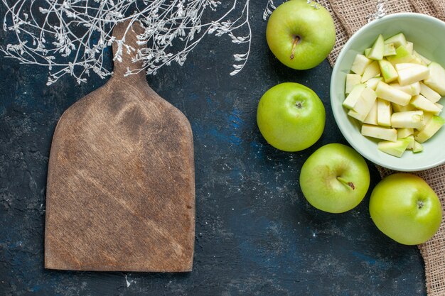 Draufsicht der grünen Äpfel weich und saftig mit geschnittenem Apfel innerhalb Platte auf dunkelblauem Schreibtisch, Fruchtfrischnahrungsmittelgesundheitsvitamin