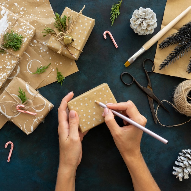 Kostenloses Foto draufsicht der hände, die weihnachtsgeschenk verzieren