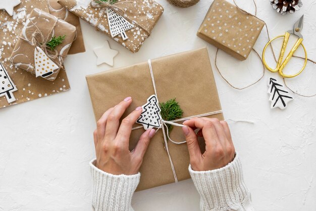 Draufsicht der Hände, die Weihnachtsgeschenke binden