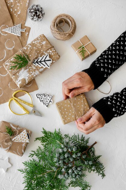 Draufsicht der Hände, die Weihnachtsgeschenke vorbereiten