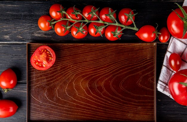 Draufsicht der halb geschnittenen Tomate im Tablett und der ganzen auf Holz