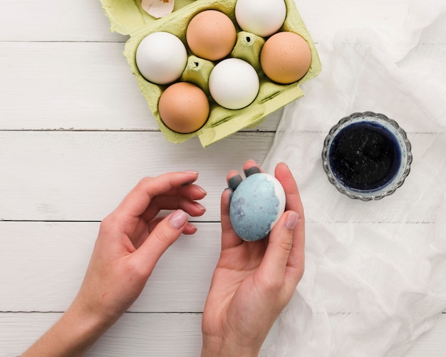 Kostenloses Foto draufsicht der hand gefärbtes ei für ostern halten