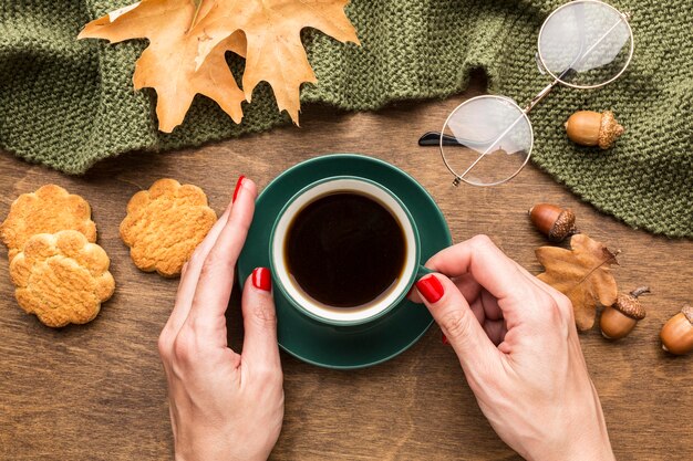 Draufsicht der Kaffeetasse mit Herbstlaub und Gläsern