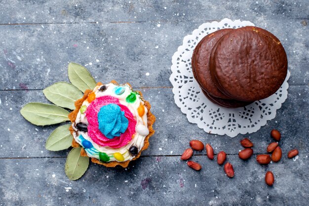 Draufsicht der köstlichen Schokoladenkuchenrunde gebildet mit Sahnekuchen lokalisiert auf grauem, backen Schokoladenkuchen-Kakaosüßkeks