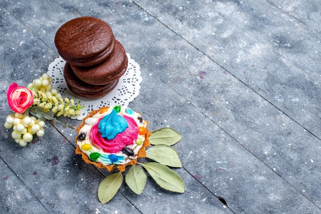 Kostenloses Foto draufsicht der köstlichen schokoladenkuchenrunde gebildet mit sahnetorte lokalisiert auf grauem, backen schokoladenkuchen-kakaosüßkekszuckerzucker