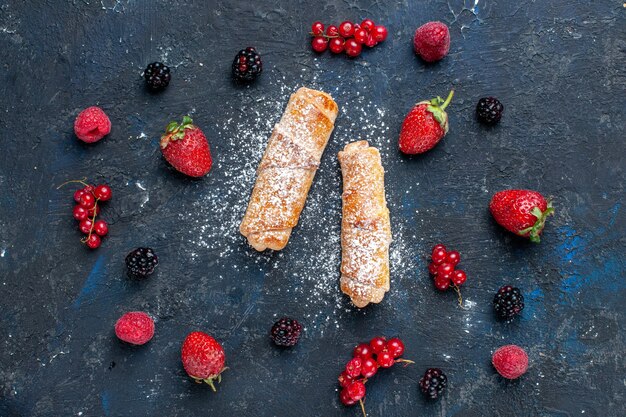 Draufsicht der köstlichen süßen Armreifen mit der Füllung lecker gebacken mit Früchten auf dunklem, backt Kuchenkeks süßes Dessert