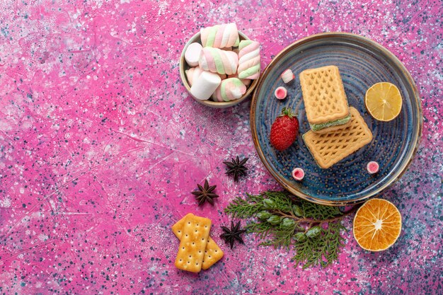 Draufsicht der köstlichen Waffeln mit Eibisch auf der rosa Oberfläche