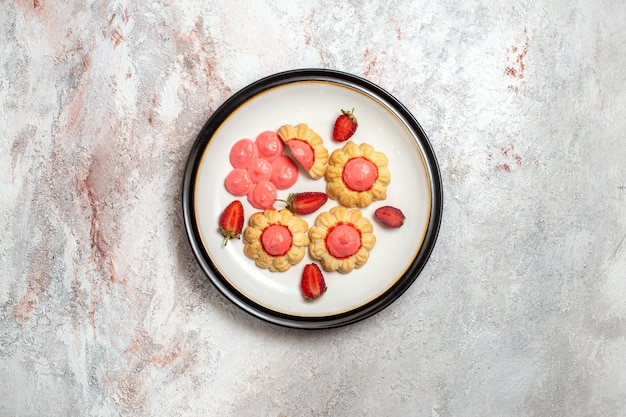 Draufsicht der köstlichen Zuckerkekse mit Erdbeergelee auf weißer Oberfläche