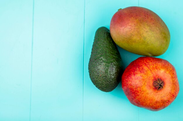 Draufsicht der Mango mit Avocado-Granatapfel auf blauer Oberfläche