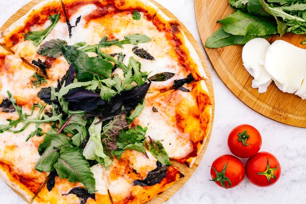 Draufsicht der Margherita-Pizza, die mit Rucola gekrönt wird