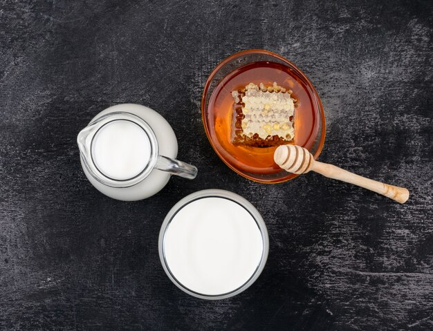 Draufsicht der Milch mit Honig auf schwarzer Oberfläche horizontal