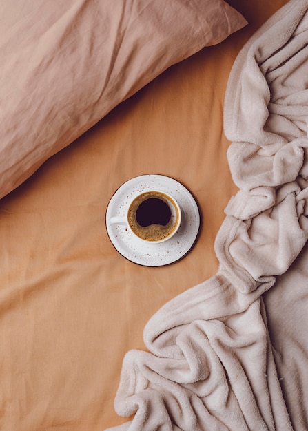 Draufsicht der Morgenkaffeetasse auf Bett