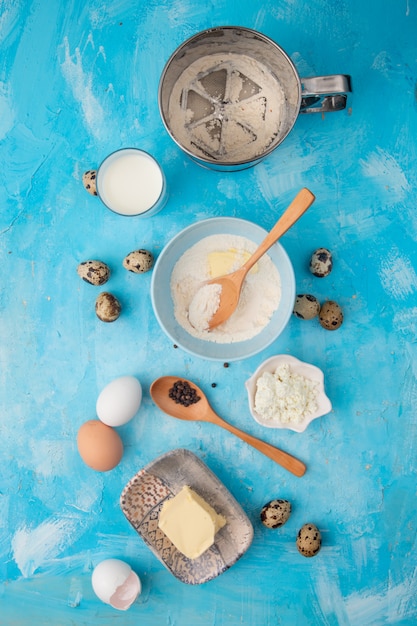 Draufsicht der Nahrungsmittel als Mehlbutter-Hüttenkäse mit Milchei schwarzer Pfeffer auf blauem Hintergrund