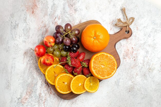 Draufsicht der Orangen-Trauben und der Erdbeeren der frischen Fruchtzusammensetzung auf der weißen Oberfläche