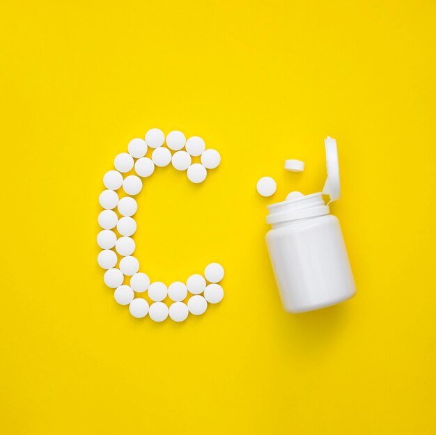 Draufsicht der Pillen, die Buchstaben und Plastikbehälter buchstabieren