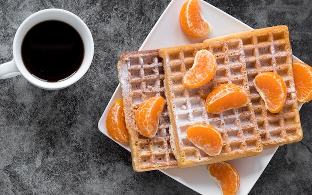 Kostenloses Foto draufsicht der platte mit waffeln und mandarinen