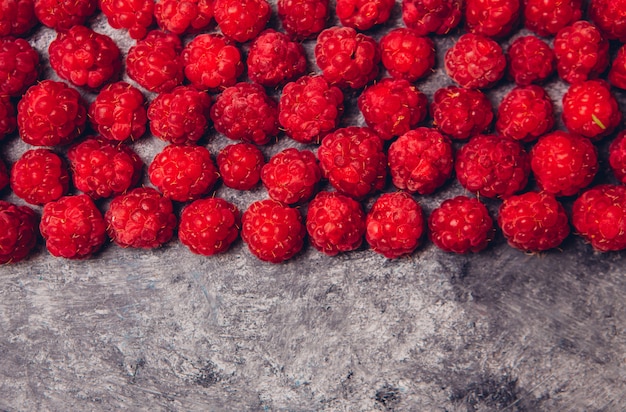 Draufsicht der roten Himbeeren auf einem dunkelgrauen Tisch