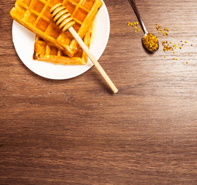 Draufsicht der süßen belgischen Waffel mit dem Honig- und Bienenpollen