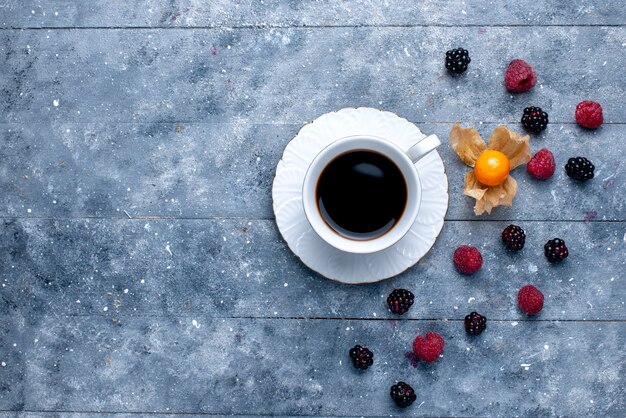 Draufsicht der Tasse Kaffee mit verschiedenen Beeren auf grauer Beerenfruchtkaffeegetränkfarbe