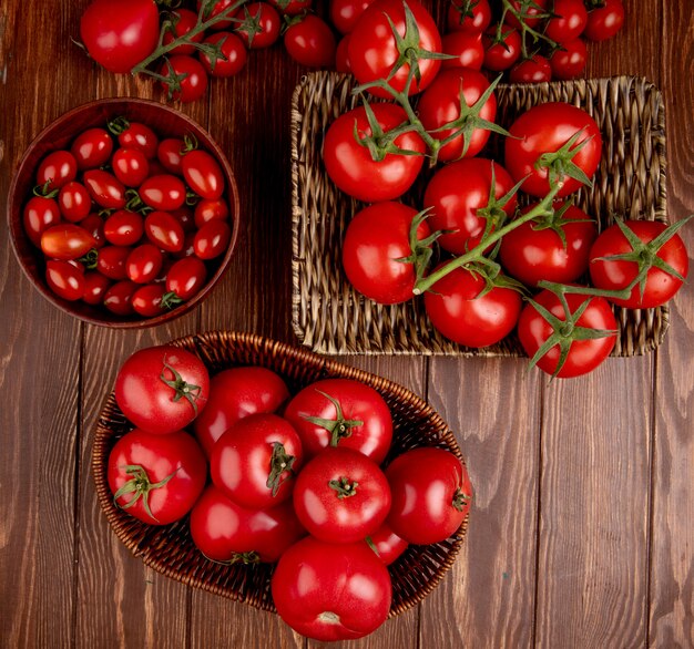 Draufsicht der Tomaten im Schüsselkorb und im Teller auf Holzoberfläche