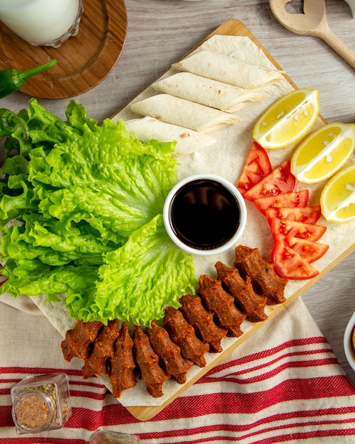 Draufsicht der türkischen Kofte-Fleischsalat-Tomaten-Zitrone