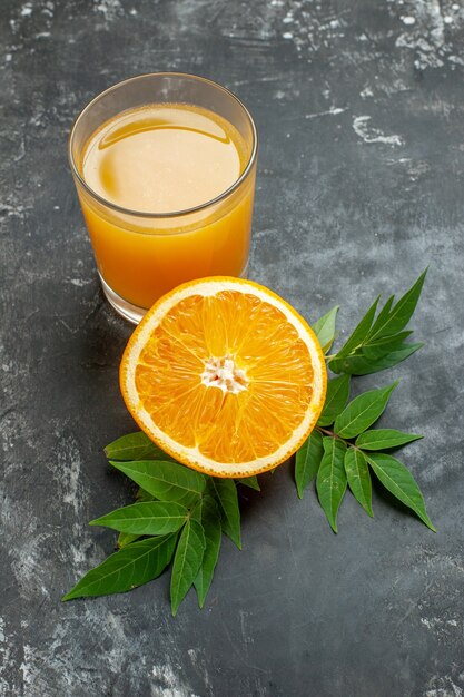 Draufsicht der Vitaminquelle geschnittene frische Orangen und Saft mit Blättern auf grauem Hintergrund