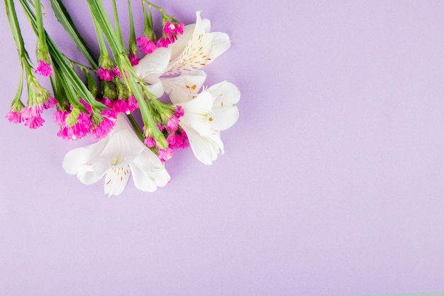 Draufsicht der weißen und rosa Farbe Alstroemeria und Statice Blumen auf lila Hintergrund mit Kopienraum