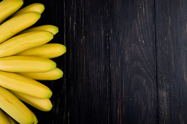 Draufsicht des Bündels von Bananen auf rustikalem Holz mit Kopienraum