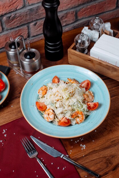 Draufsicht des Caesar-Salats mit Garnelen und Parmesankäse auf dem Tisch