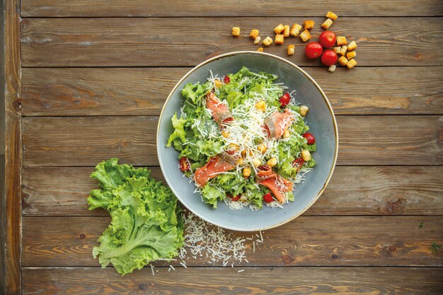 Draufsicht des Caesar-Salats mit geräuchertem Lachs und geriebenem Käse