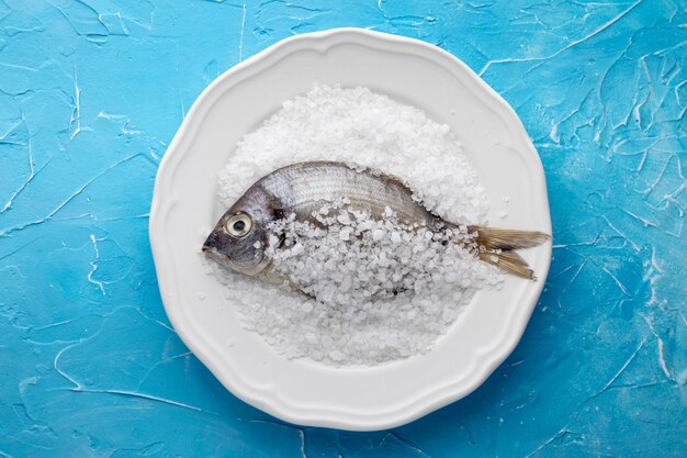 Draufsicht des Fisches auf Platte mit Salz