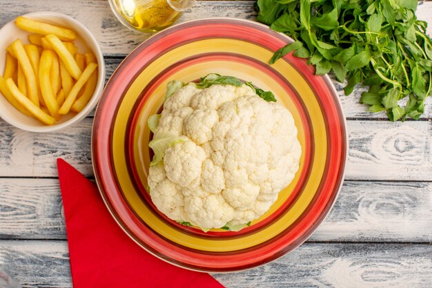 Draufsicht des frischen blumenkohls mit pommes frites auf der rustikalen grauen holzoberfläche