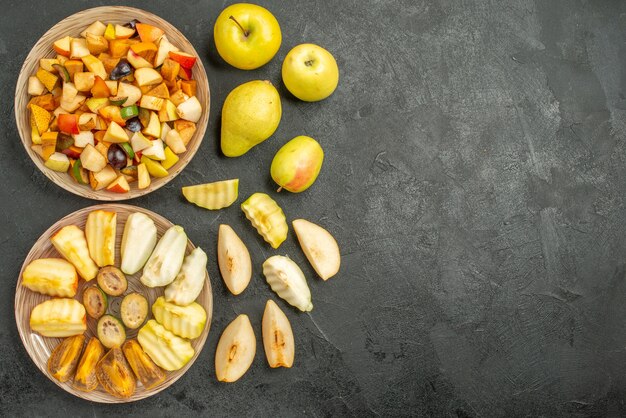 Draufsicht des fruchtigen Salats mit frisch geschnittenen Früchten auf dem dunklen Hintergrund