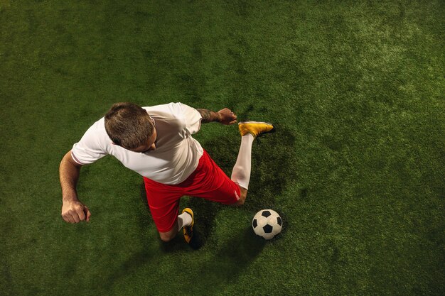 Draufsicht des Fußballs oder des Fußballspielers auf grünem Gras