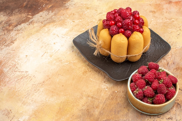 Draufsicht des gedeckten Tisches mit einem Geschenkkuchen und Früchten für Gäste auf Mischfarben-Tischmaterial