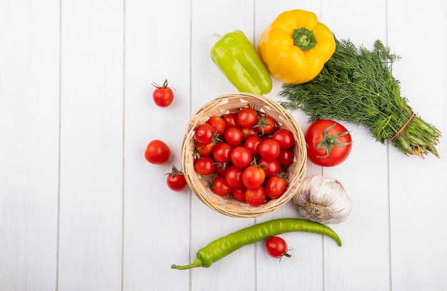 Draufsicht des Gemüses als Korb der Tomate mit Pfeffer Knoblauchknolle und Tomatenbündel Dill herum auf Holzoberfläche