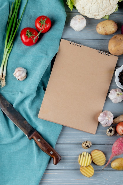 Kostenloses Foto draufsicht des gemüses als tomaten-knoblauch-ei-kartoffel mit messer auf stoff auf hölzernem hintergrund mit kopienraum