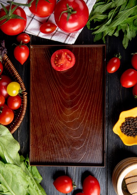 Draufsicht des Gemüses als Tomatengrünminze verlässt Spinat und schneidet Tomate in Schale auf Holz