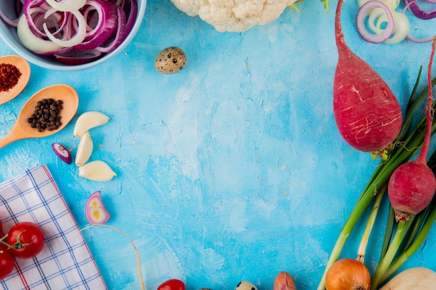 Draufsicht des Gemüses als Zwiebel-Knoblauch-Rettich und andere mit Gewürzen und Ei auf blauem Hintergrund mit Kopienraum